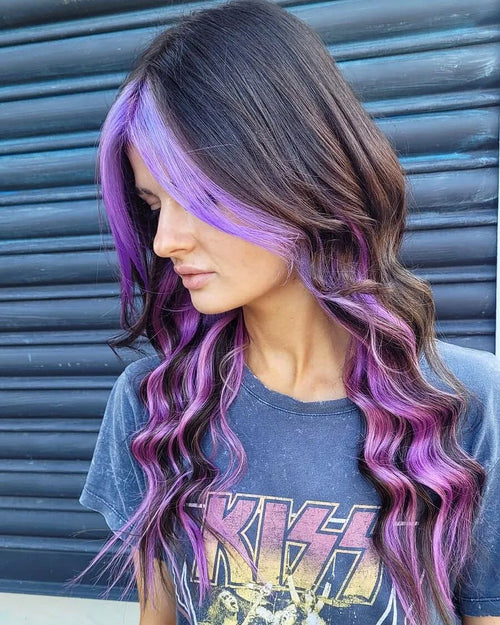 A woman with Manic Panic purple money piece in her hair and a black shirt