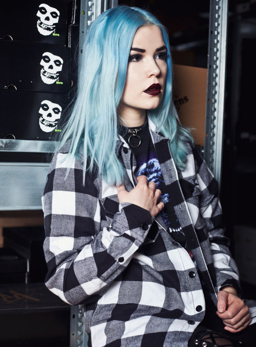 A woman sporting Atomic Turquoise to light blue hair and a plaid shirt.