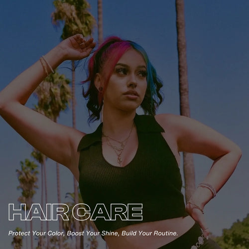 Person with half pink, half blue high ponytail hair standing outdoors under palm trees, wearing a black sleeveless top. Text overlay reads ‘Hair Care – Protect Your Color, Boost Your Shine, Build Your Routine