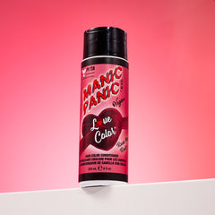 A bottle of Manic Panic® LOVE COLOR™ ROCK ME RED® conditioner. The packaging features red and blue graphics with text emphasizing the vegan formulation.