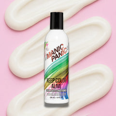 Bottle of Organic Panic Keep Color Alive conditioner with colorful label on a pink background and conditoner texture zig zag