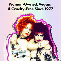 Two women with vibrant hairstyles posing together, with text about being woman-owned, vegan, and cruelty-free since 1977.