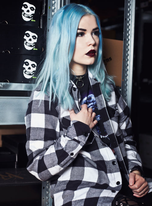 Model showcasing Manic Panic Atomic Turquoise hair color with long blue hair and a black and white plaid shirt