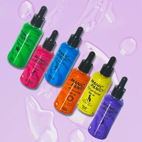 Set of Manic Panic bath and body oil bottles in various colors on a matching purple background
