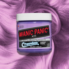 Manic Panic Classic High Voltage semi-permanent hair dye in shade Velvet Violet a vibrant, vegan hair color. Image shows a jar of Velvet Violet hair dye placed on top of a wavy pastel violet hair swatch.
